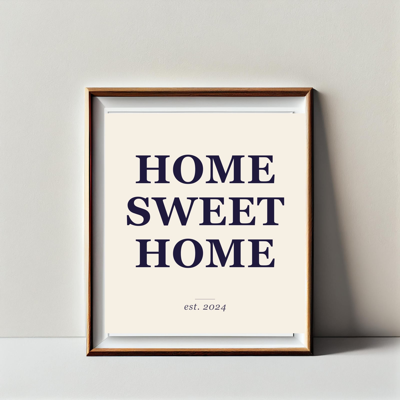 Etsy quote print mockup: HOME SWEET HOME headline on three lines with "est. 2024" description, framed in oak